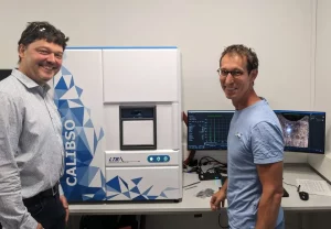Employees with the CALIBSO analysis system in the laboratory, supported by modern software on two monitors.