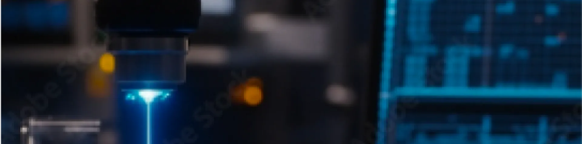 Laseranalyse im Labor: Ein blauer Laserstrahl trifft auf eine Probe, während Messdaten auf einem Monitor im Hintergrund sichtbar sind.